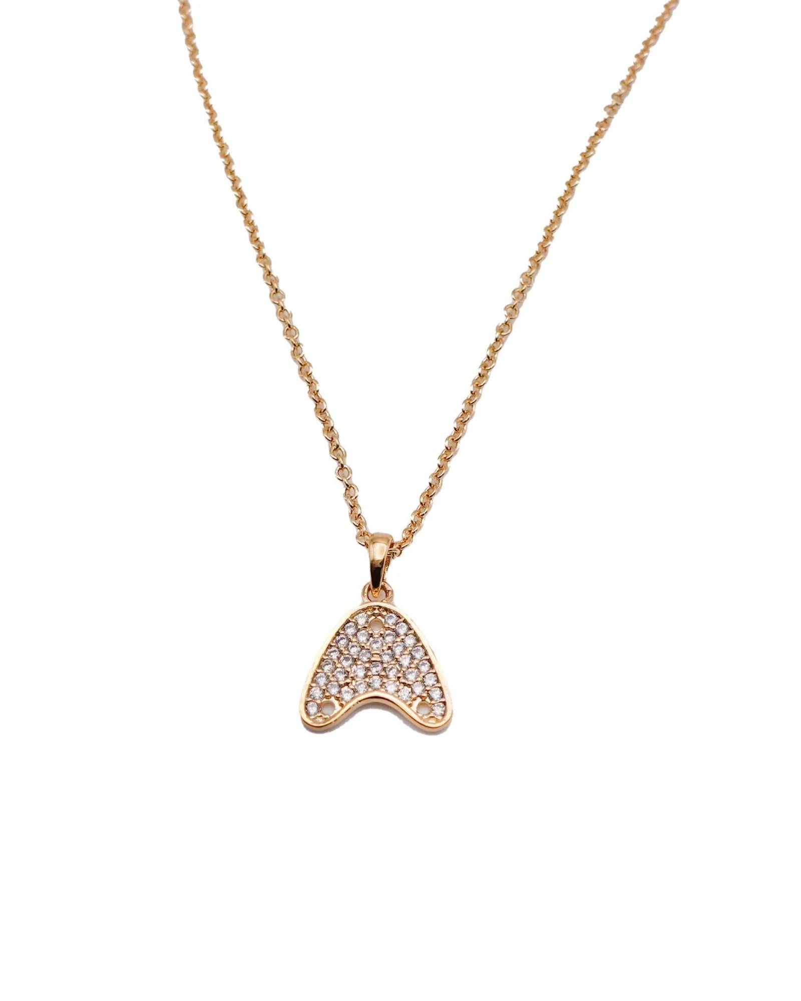 A gold-toned necklace featuring a pendant shaped like the tap shoe tap, adorned with small clear pavé stones, shown against a plain white background.