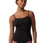 A woman modeling a black camisole-style leotard with thin shoulder straps against a plain white studio background.