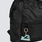 Black backpack with a keychain featuring a gymnastics design on a light gray background