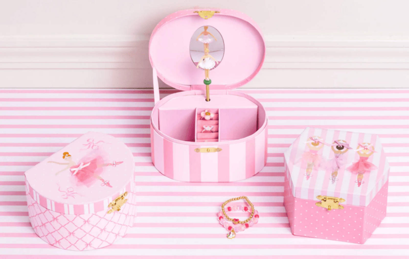 Pink jewelry box with accessories on a striped pink and white background
