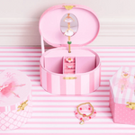 Pink jewelry box with accessories on a striped pink and white background