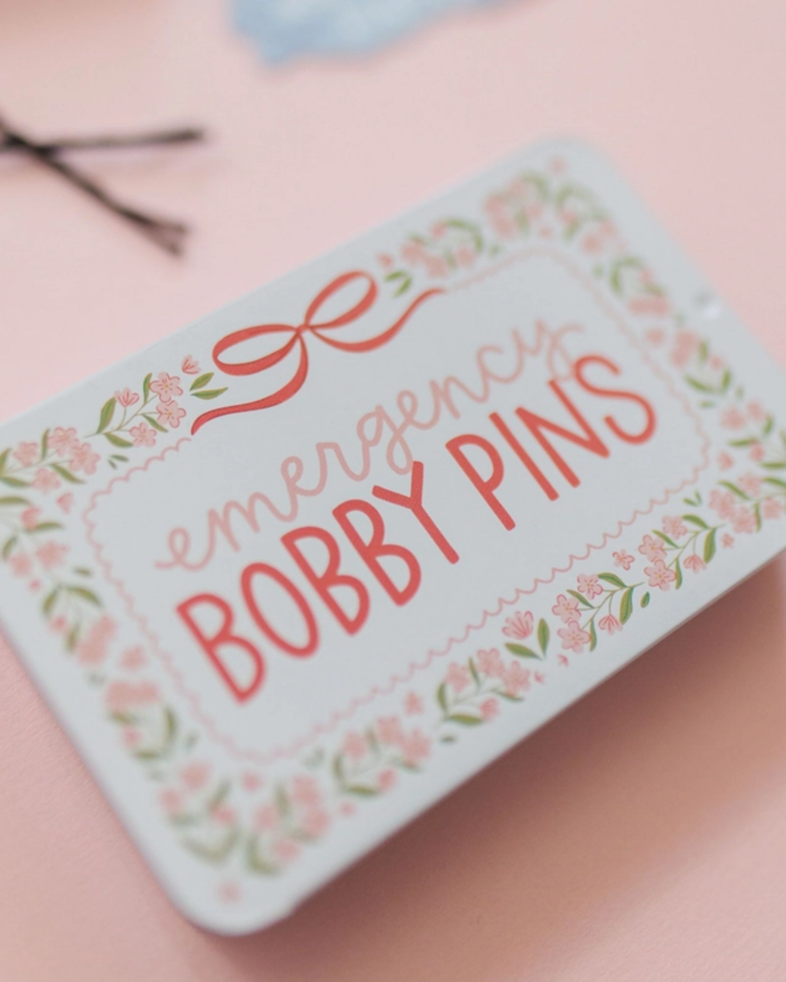 Tin box with 'Emergency Bobby Pins' text on a pink background