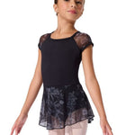 Young girl wearing a black ballet outfit with floral lace skirt on a white background