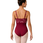 A woman modeling a burgundy ballet leotard from the back, paired with light pink tights, against a solid white background.