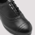 Black leather shoe on a light gray background