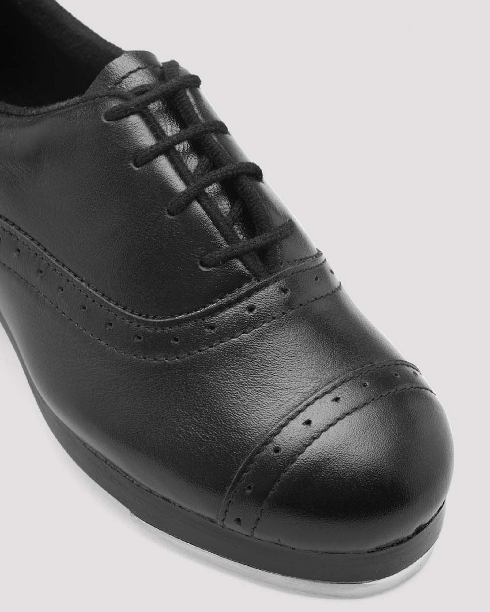 Black leather shoe on a light gray background