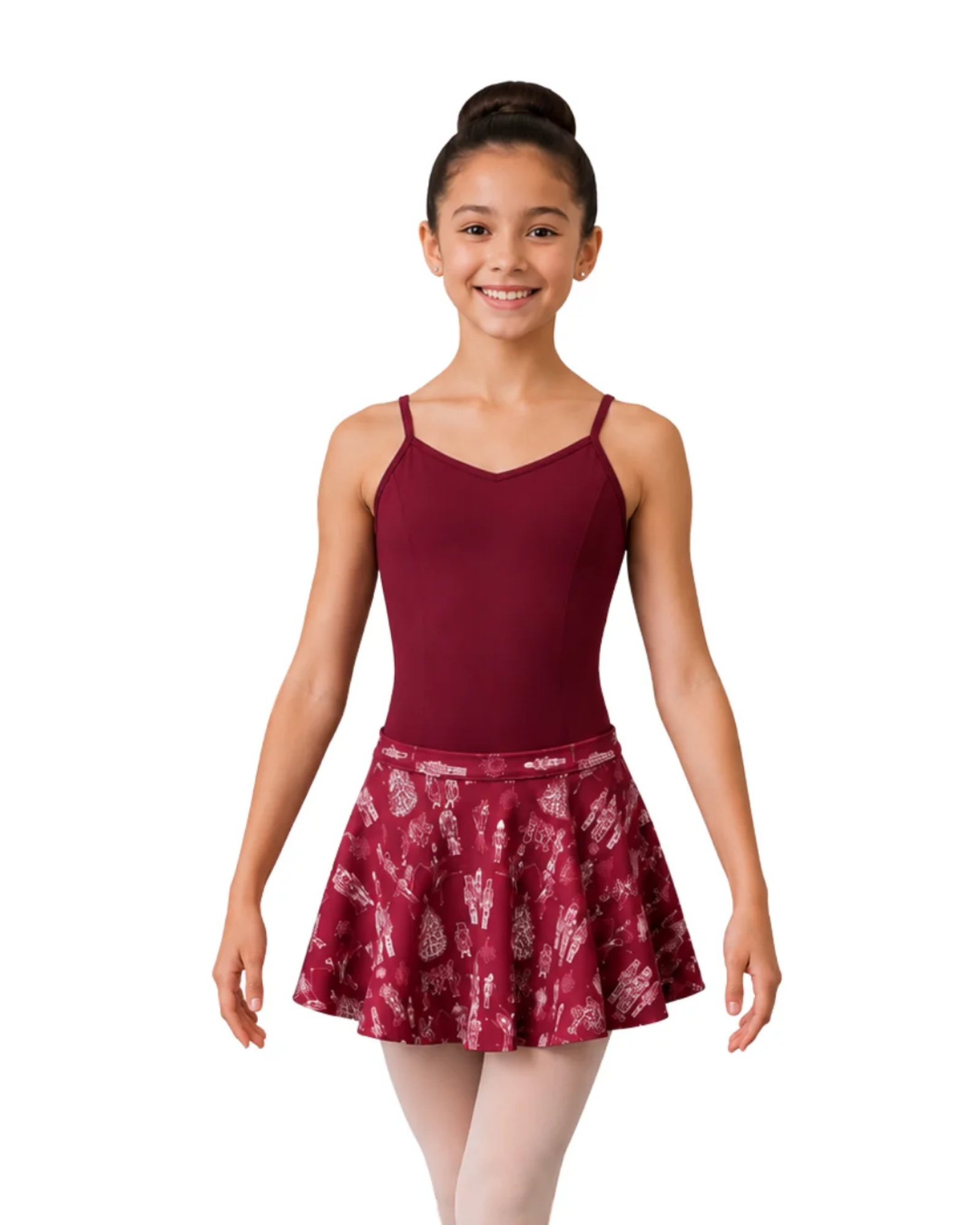 A young girl with her hair in a bun stands against a white background wearing a burgundy dance leotard top and a matching Nutcracker patterned burgundy and white dance skirt.