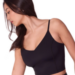 Woman wearing a black dance bra and leggings on a white background