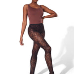 Model wearing brown bodysuit and black lace tights on a white background