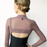 A woman shown from the back wearing a black leotard and a sheer mauve long-sleeve crop top, against a plain white background