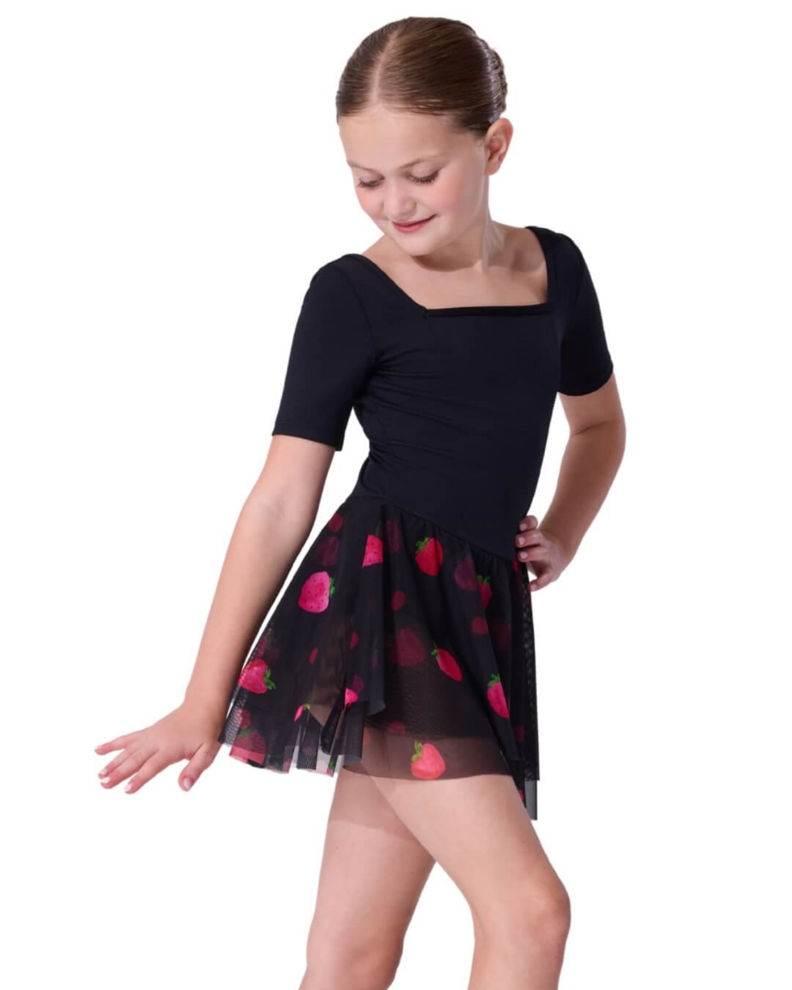 Young girl wearing a black dress with red strawberry patterns on the skirt on a white background