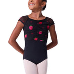Young girl wearing a black leotard with strawberry patterns on a white background