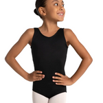 A young girl with her hair in a bun poses in a sleeveless black dance leotard and white tights against a solid white background.