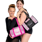 Two women holding pink and black 'Dance' bags on a white background