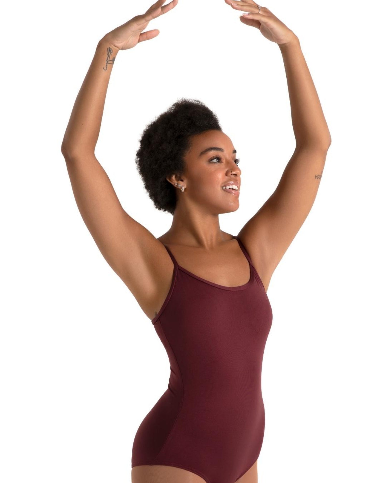 Woman wearing a maroon leotard against a white background
