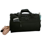 Black duffel bag with a phone and shoes on a white background