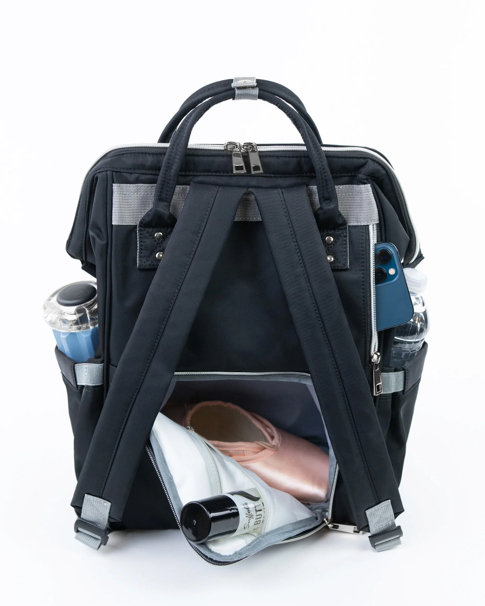 Black backpack with compartments containing a phone, bottle, and other items on a white background