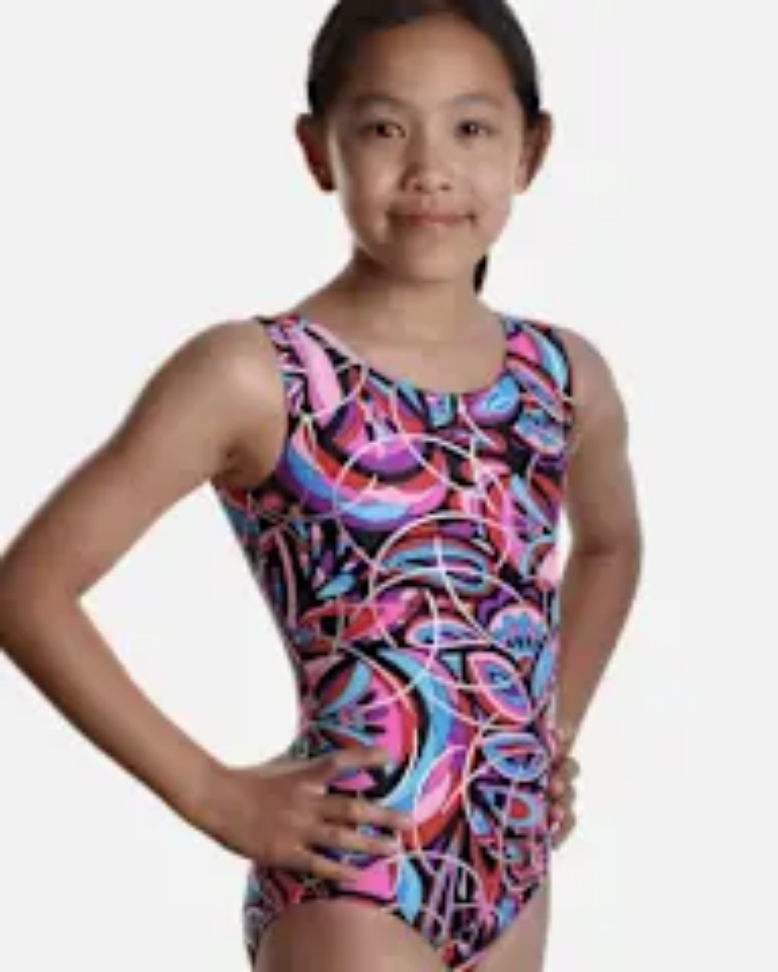 Young girl wearing a colorful leotard 
with a pattern on a plain background