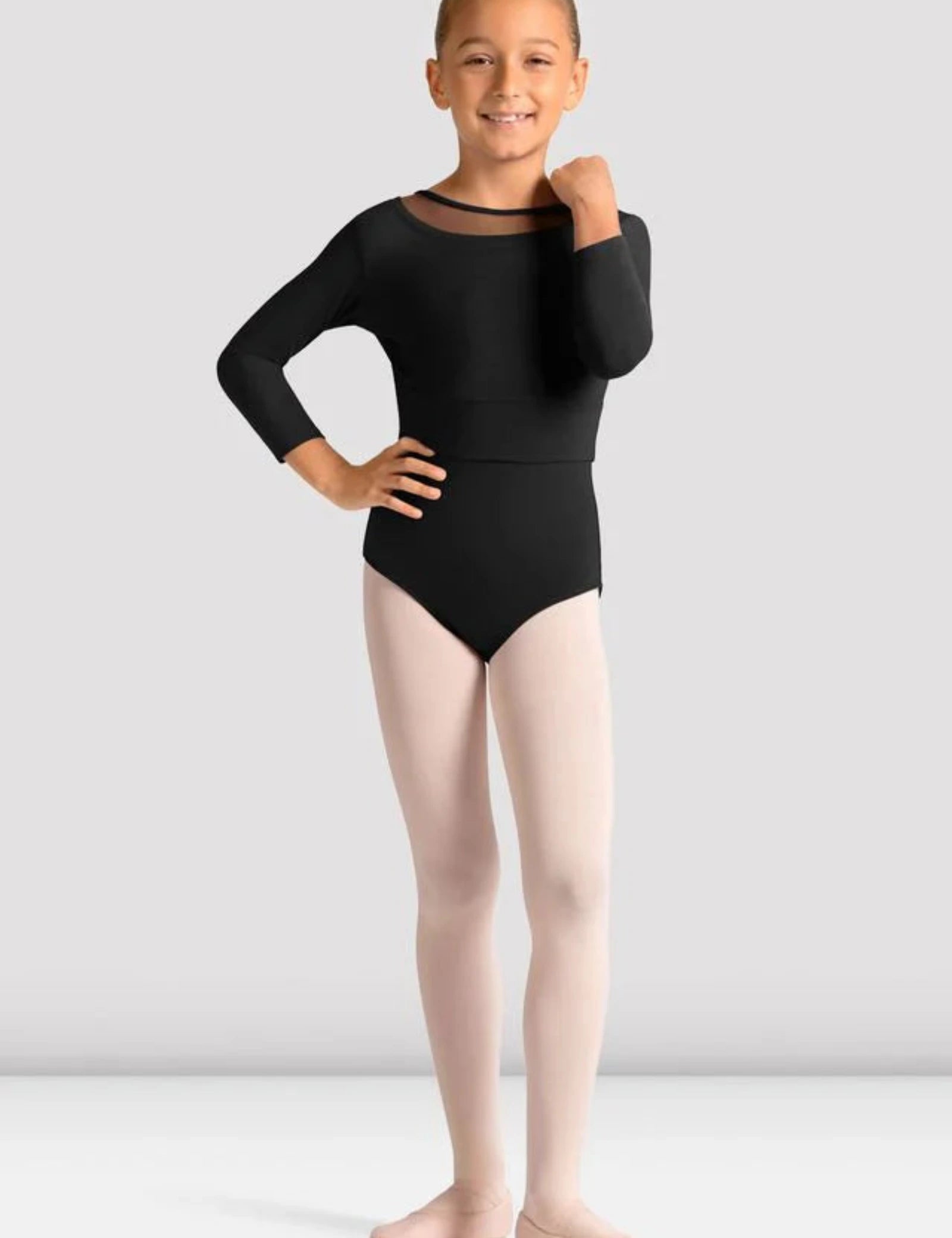 Young girl wearing a black leotard and pink tights on a white background