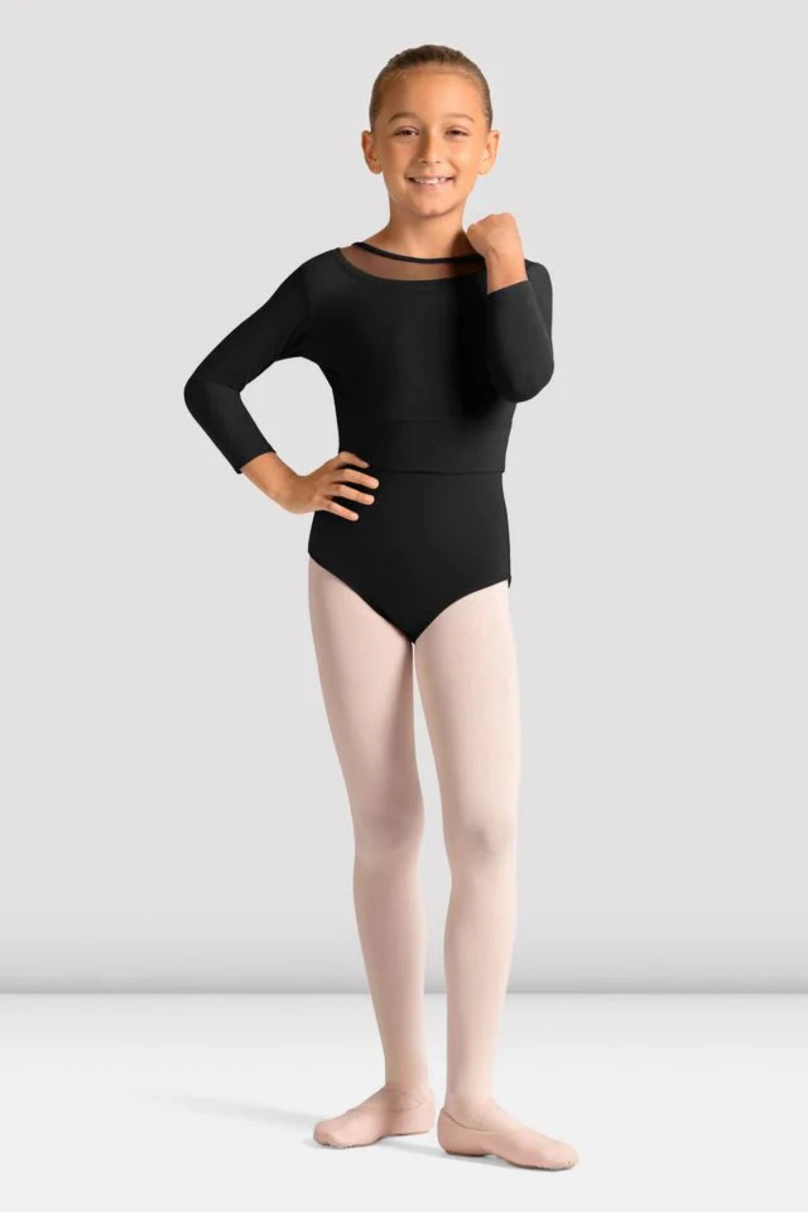 Young girl wearing a black leotard and pink tights on a white background
