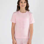 Young girl wearing a pink pajama set with a white background