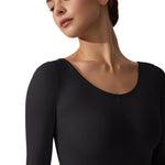 Woman wearing a black long-sleeve top against a white background