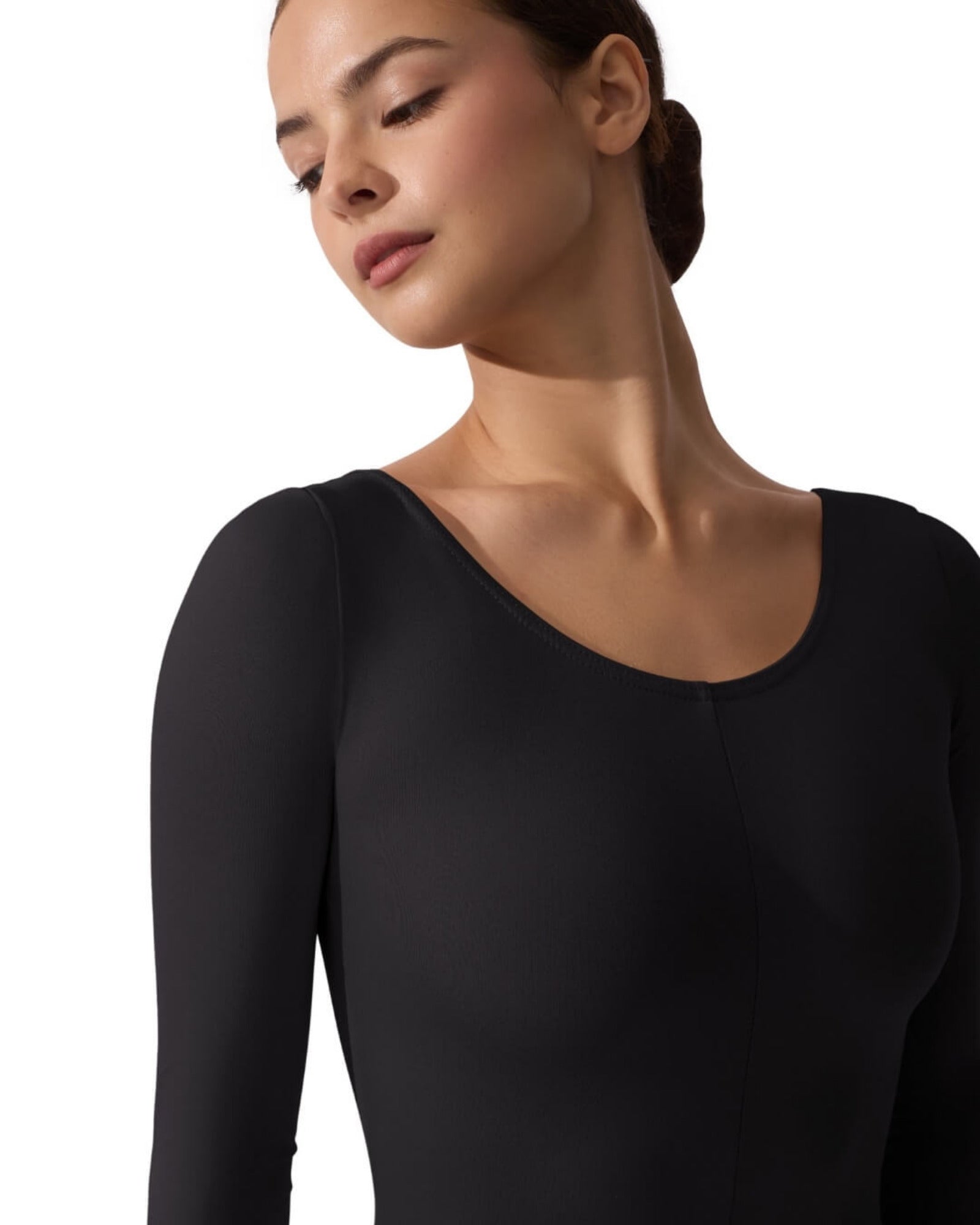 Woman wearing a black long-sleeve top against a white background
