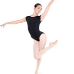 Ballerina in a black leotard and beige tights posing on a white background