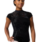 Person wearing a black floral-patterned leotard on a white background