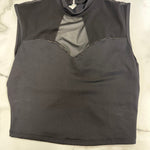 A dark black sleeveless mock neck top with a sheer mesh yoke, laid flat on a white marble surface.