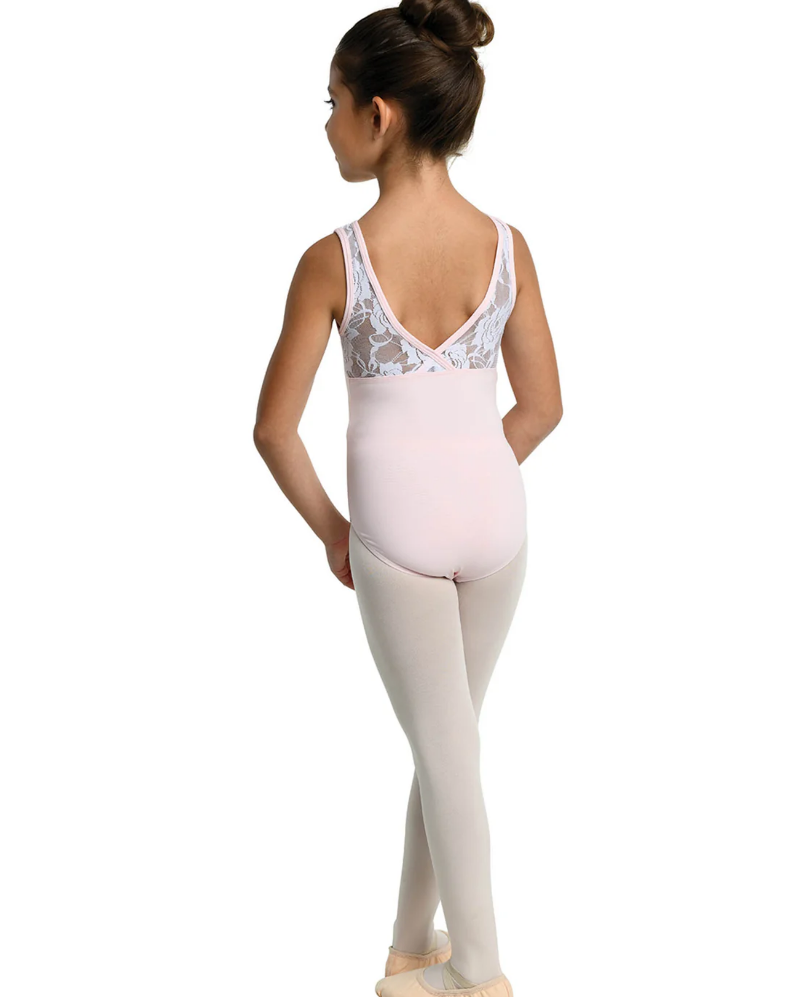 A young girl dancer shown from the back wearing a pale pink leotard with white lace detailing on the back and light pink tights, standing on a white background.