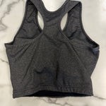 A dark gray heather racerback sports bra laid flat on a white marble surface.