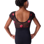 A girl viewed from the back wearing a black dance leotard with sheer mesh shoulder panels and pink strawberry prints, paired with light pink tights, against a plain white background.