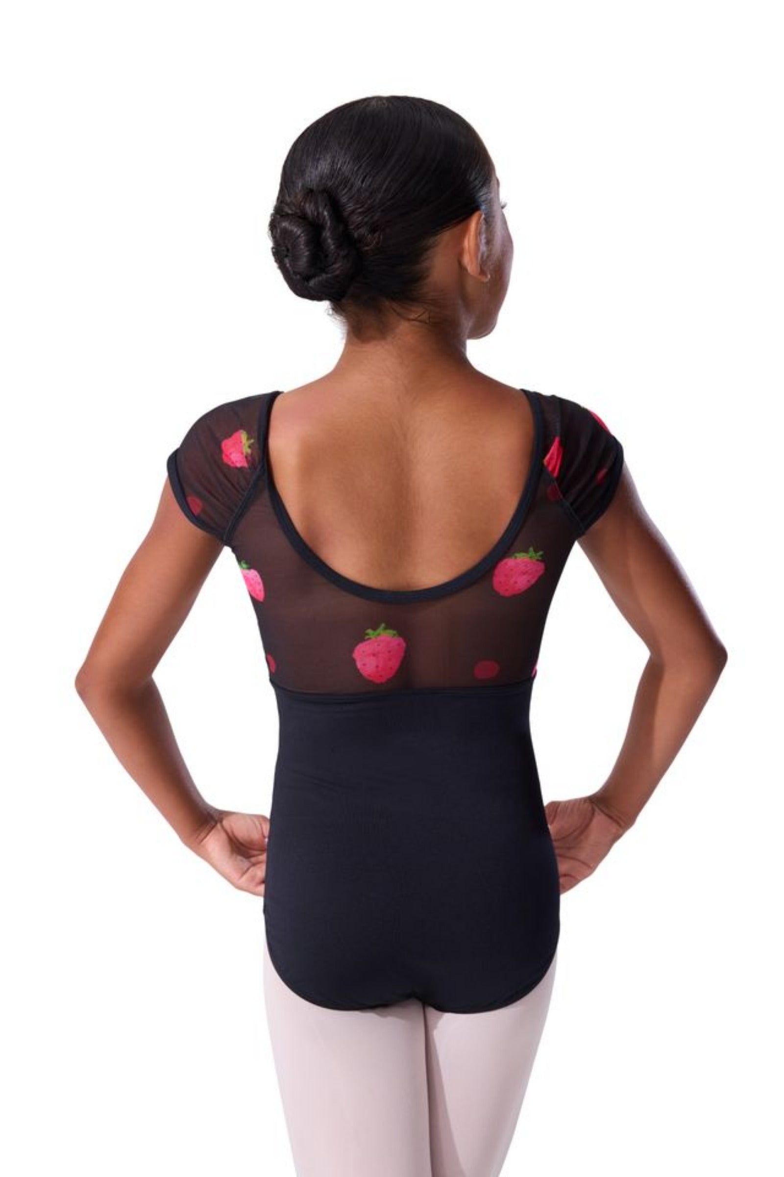 A girl viewed from the back wearing a black dance leotard with sheer mesh shoulder panels and pink strawberry prints, paired with light pink tights, against a plain white background.