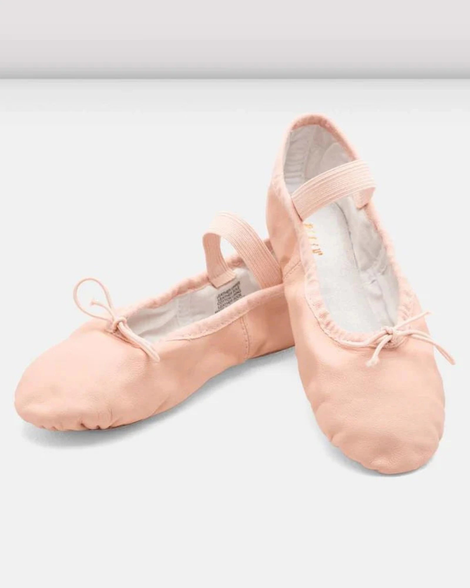 Pair of pink ballet shoes on a light gray background