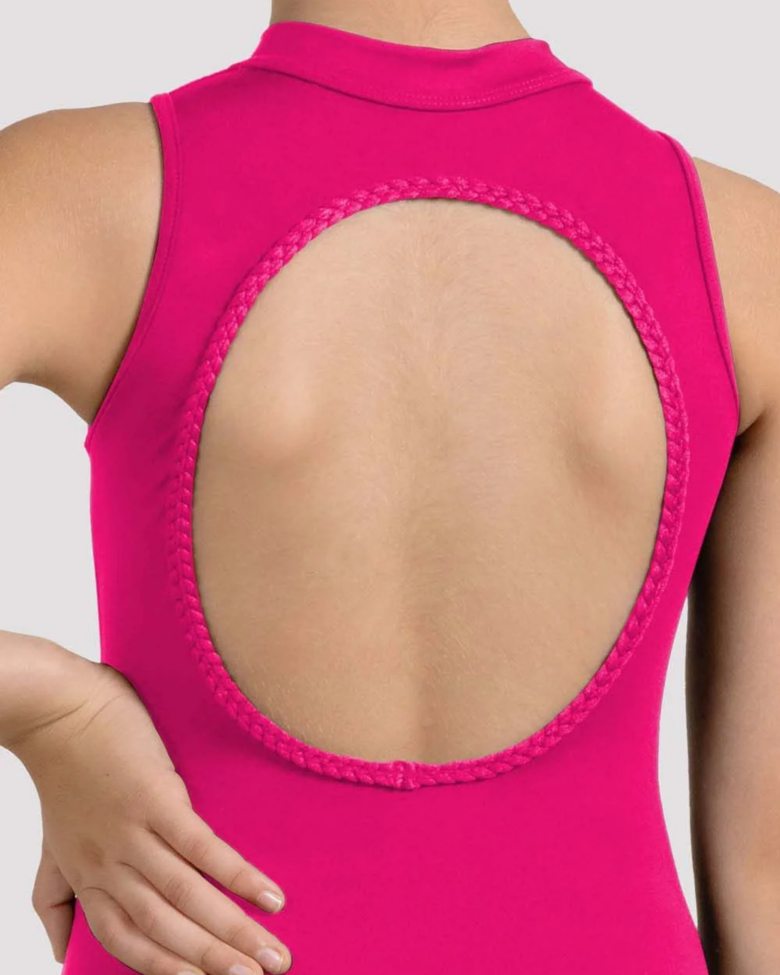 Close-up back view of a sleeveless bright pink garment with a large oval cutout bordered by braided trim, worn by a model against a light gray studio background.