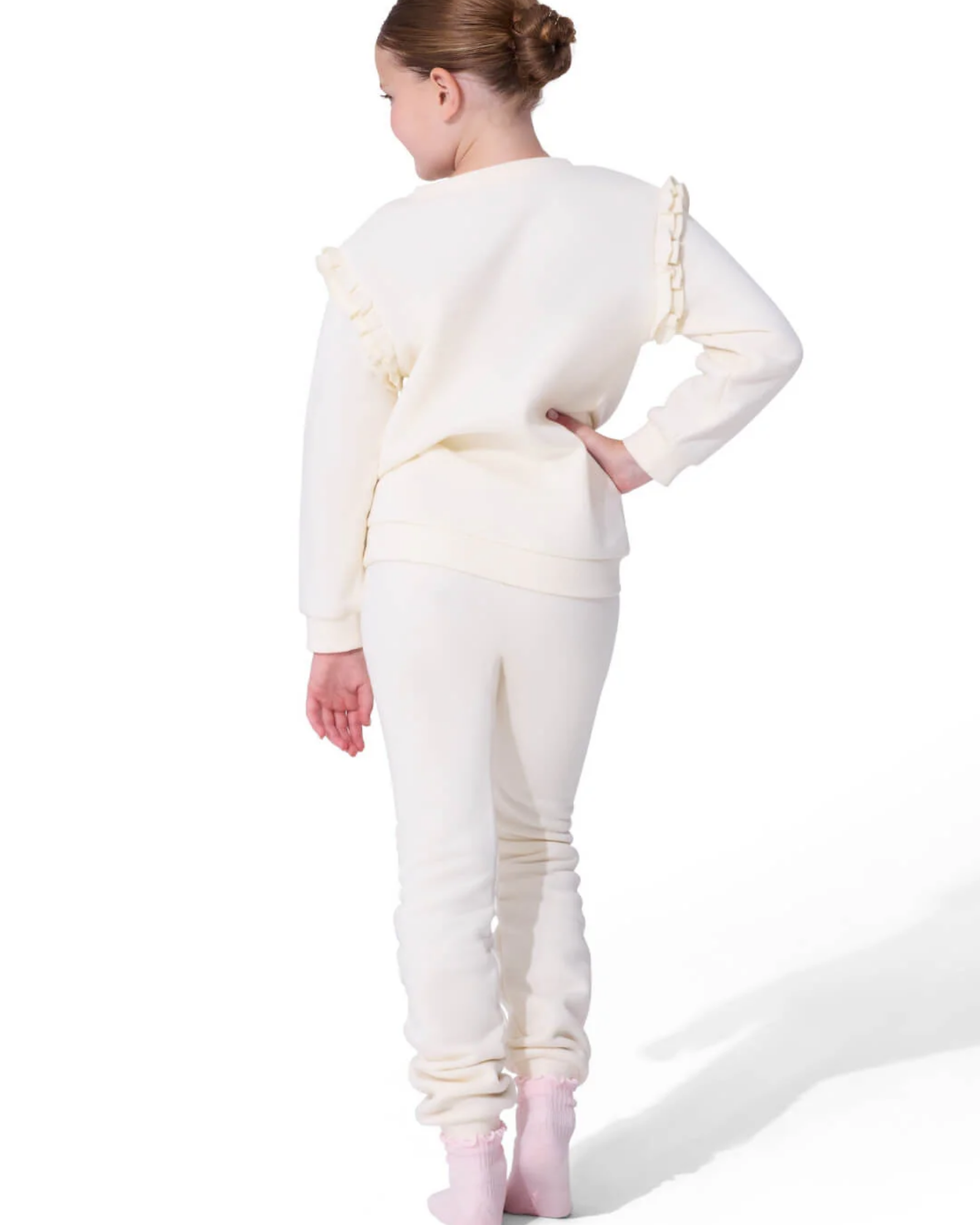 Person wearing a white outfit with ruffled sleeves on a white background