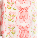 A folded plush blanket featuring a pattern of pink ballet shoes and green floral stems on a white background.