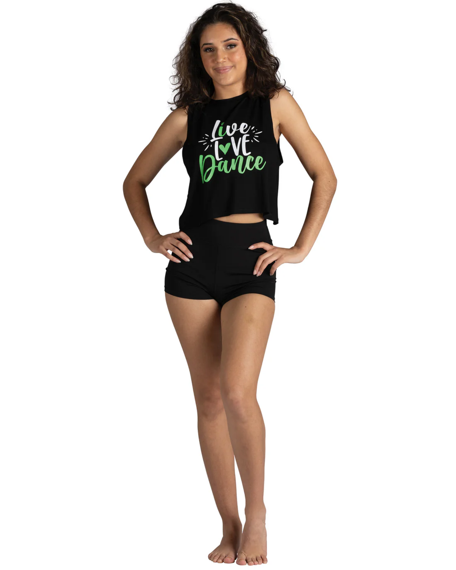 A woman modeling a black sleeveless crop top and matching black shorts against a plain white background. The top features a graphic print that reads 'live love dance' in white and green script.