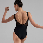 Woman wearing a black leotard with sheer back panels on a gray background