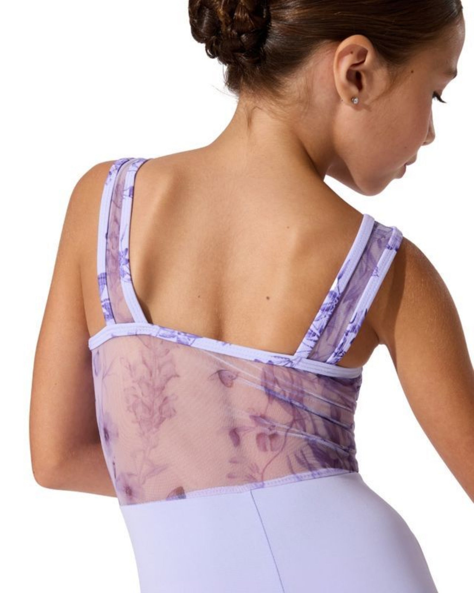 Woman wearing a sheer back leotard with floral pattern on a white background