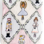 A square white plush blanket featuring a repeating pattern of ballet dancers, a nutcracker, a princess, a mouse prince, and gray geometric diamond borders.