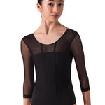 Woman wearing a black ballet leotard with sheer mesh panels on a white background