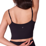 Person wearing a black dance bra and leggings on a white background