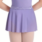 A child wearing a lavender purple dance leotard with a matching skirt and a shiny lavender waistband, paired with light pink tights, shown from the chest down against a white background.