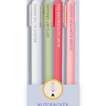 Four slim pens in pastel white, sage green, coral red, and light pink, displayed in a clear vertical card package. Each pen has a different fairy-themed phrase printed vertically: 'BELIEVE IN THE MAGIC,' 'LET'S GET CRACKIN'', "IN MY NUTCRACKER ERA", SUGARPLUM FAIRY ENERGY".