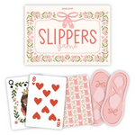 Slippers game card set by Pippi Post, featuring a floral-bordered title card reading 'SLIPPERS game,' three illustrated playing cards, and a pair of pink slipper-shaped pieces on a white background.