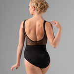 Woman wearing a black leotard with sheer back panels on a gray background