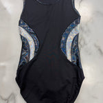 A sleeveless black leotard with metallic blue and silver patterned side panels, laid flat on a white marble surface.