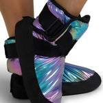 A pair of ankle support boots with black straps and a holographic, iridescent finish shifting between purple, blue, and green, shown on a model's feet against a white background.